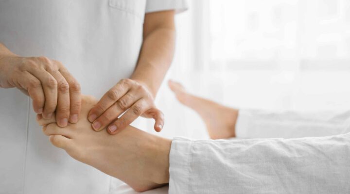 Enfermera revisando el pie de un paciente para prevenir complicaciones del pie diabético en Granada.