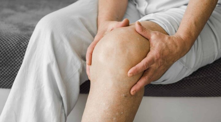 Persona mayor con dolor en la pierna a causa de problemas de circulación venosa, relacionados con úlceras venosas.