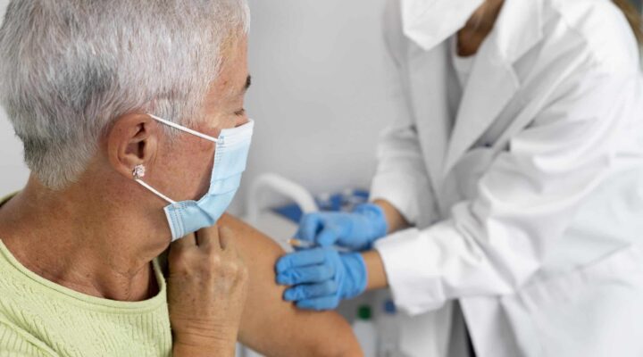 Enfermera administrando la vacuna de la gripe 2025-2026 a una mujer mayor en Granada