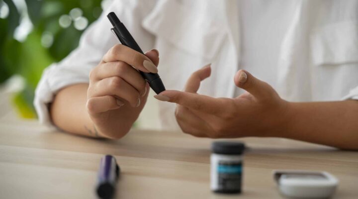 Mujer midiendo su nivel de glucosa en sangre como parte del control de la diabetes mellitus.