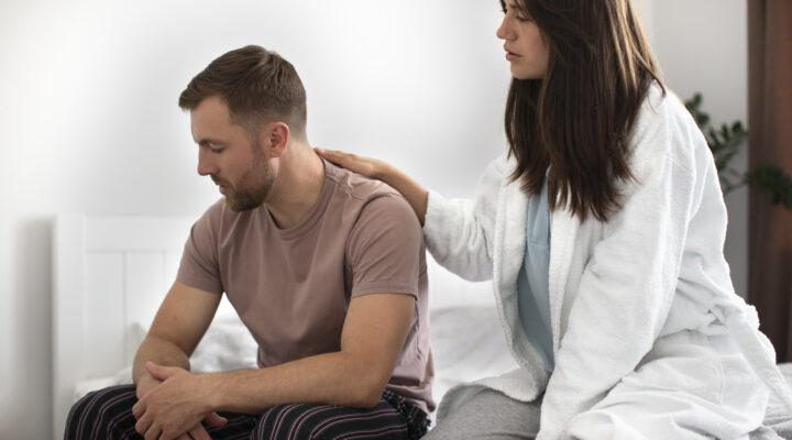 Hombre adulto experimentando dificultades relacionadas con la disfunción eréctil acompañado por su pareja